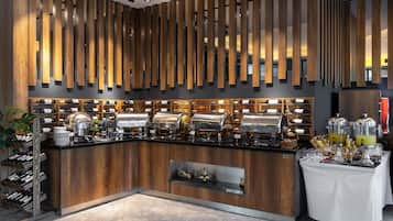 A buffet setup with various food stations, a wine rack, and a coffee station.