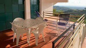 A balcony with a table and chairs, a view of the countryside, and a green wall. - Tuscany Hill / Sea Castagneto Carducci (Castagneto Carducci)