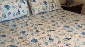 A bed with a quilt featuring a marine theme, including fish, starfish, and coral. - Discounted 30 Day Minimum Stay. 2bd. 2bth. Private 2nd floor Condo & balconies. (Corpus Christi)