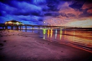 Un muelle que se adentra en el agua con un edificio al final.
