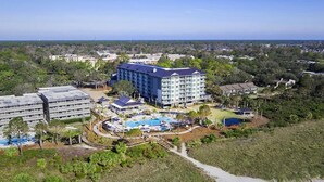 Un resort con un gran edificio, una piscina y un campo de golf.