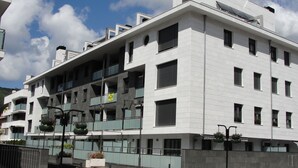 Un edifici d'alguns pisos amb un disseny arquitectònic modern, amb balcons i grans finestres.