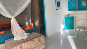 Une chambre comprenant un lit, une commode en bois, une salle de bain et un coin cuisine.