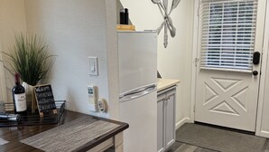 A kitchen with a white refrigerator, wooden countertop, and a welcome sign. - Your own modern treehouse overlooking Bidwell Park (Chico)