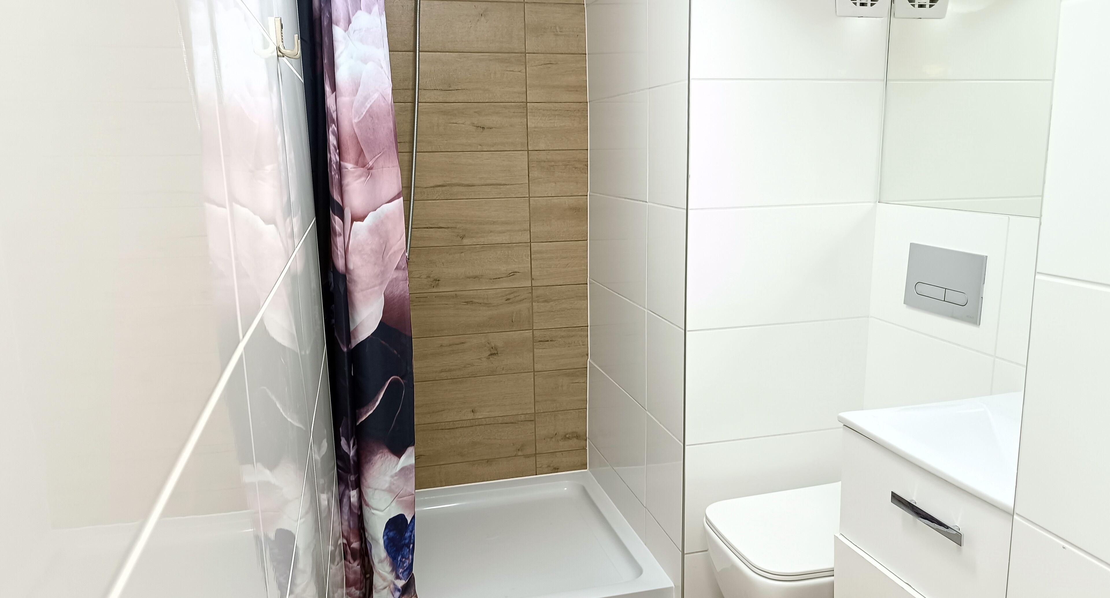 A bathroom with a shower, a toilet, and a sink.