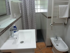 Een douche, een haardroger, een bidet, handdoeken
