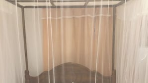 Un lit à baldaquin avec une couvre-lit à rayures.