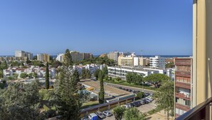 A residential area with apartment buildings, a parking lot, and a clear blue sky. - FLH Vilamoura Cozy Studio (Vilamoura)