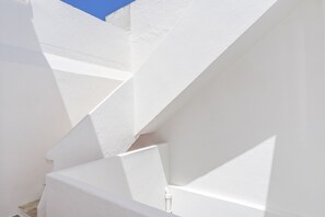 A white staircase with geometric design, leading to a higher level.