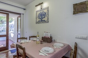 A dining area with a table set for two, a bottle of wine, a basket, and a sign indicating a restaurant.