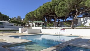 A rectangular swimming pool with clear blue water, surrounded by a white wall and a paved deck. - FLH Albufeira Açoteias Apartment (Albufeira)