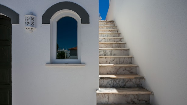 A white building with a marble staircase leading to a window. - FLH Altura Family House with Pool (Altura)