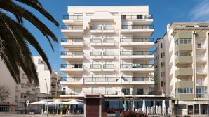A multi-story hotel with balconies, a central entrance, and outdoor seating. - FLH Armação de Pêra Ocean View Flat (Armação de Pêra)