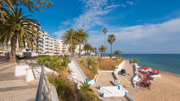 A coastal hotel with a beachside terrace, palm trees, and a clear view of the sea. - FLH Armação de Pêra Ocean View Flat (Armação de Pêra)