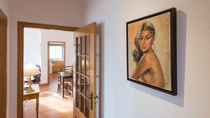 A hallway with a dining area, a painting on the wall, and a door leading to another room. - FLH Armação de Pêra Ocean View Flat (Armação de Pêra)