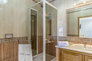 Chuveiro, secador de cabelo, toalhas de banho, shampoo