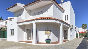 A white building with a tiled roof, a sign reading "VILA MIRA," and a large blue vase in the entrance. - FLH Albufeira Vila Mira Flat with Pool (Albufeira)