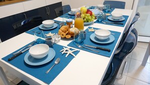 A dining table set with blue placemats, white plates, and silverware. - Ville Ninfea - 2 independent twin pool villas, 150 mt by the sea Fontane Bianche (Fontane Bianche)