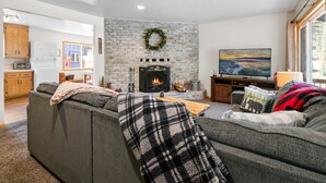 Ein modernes Wohnzimmer mit Kamin, Fernseher und einer gemütlichen Couch.