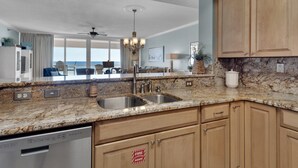 Una cocina moderna con encimeras de granito, electrodomésticos de acero inoxidable y armarios de madera.