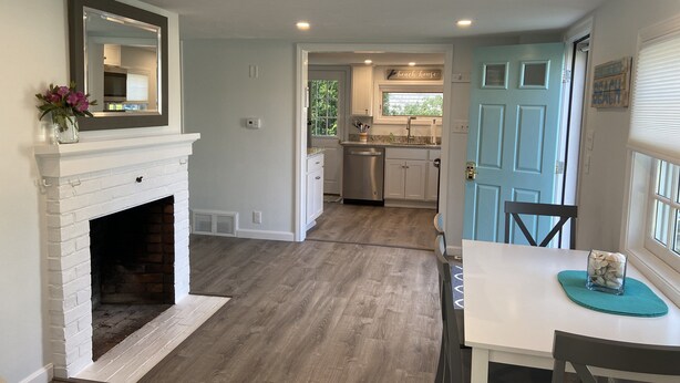 A modern kitchen with white cabinets, a built-in oven, and a window with a view of the outdoors. - Late August and fall dates available! (Dennis)