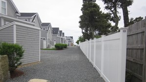 A residential street with houses, a gravel driveway, and a wooden fence. - Late August and fall dates available! (Dennis)