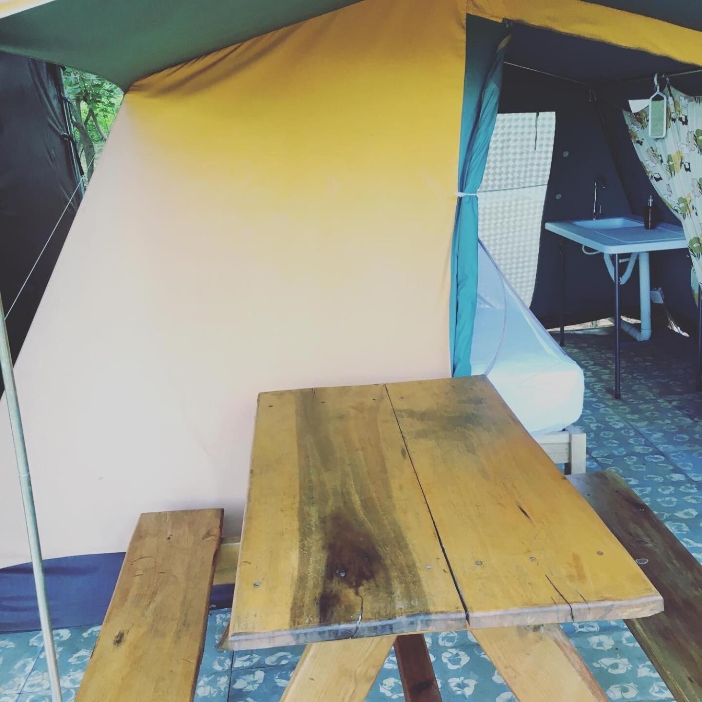 A tent with a table and a chair inside.