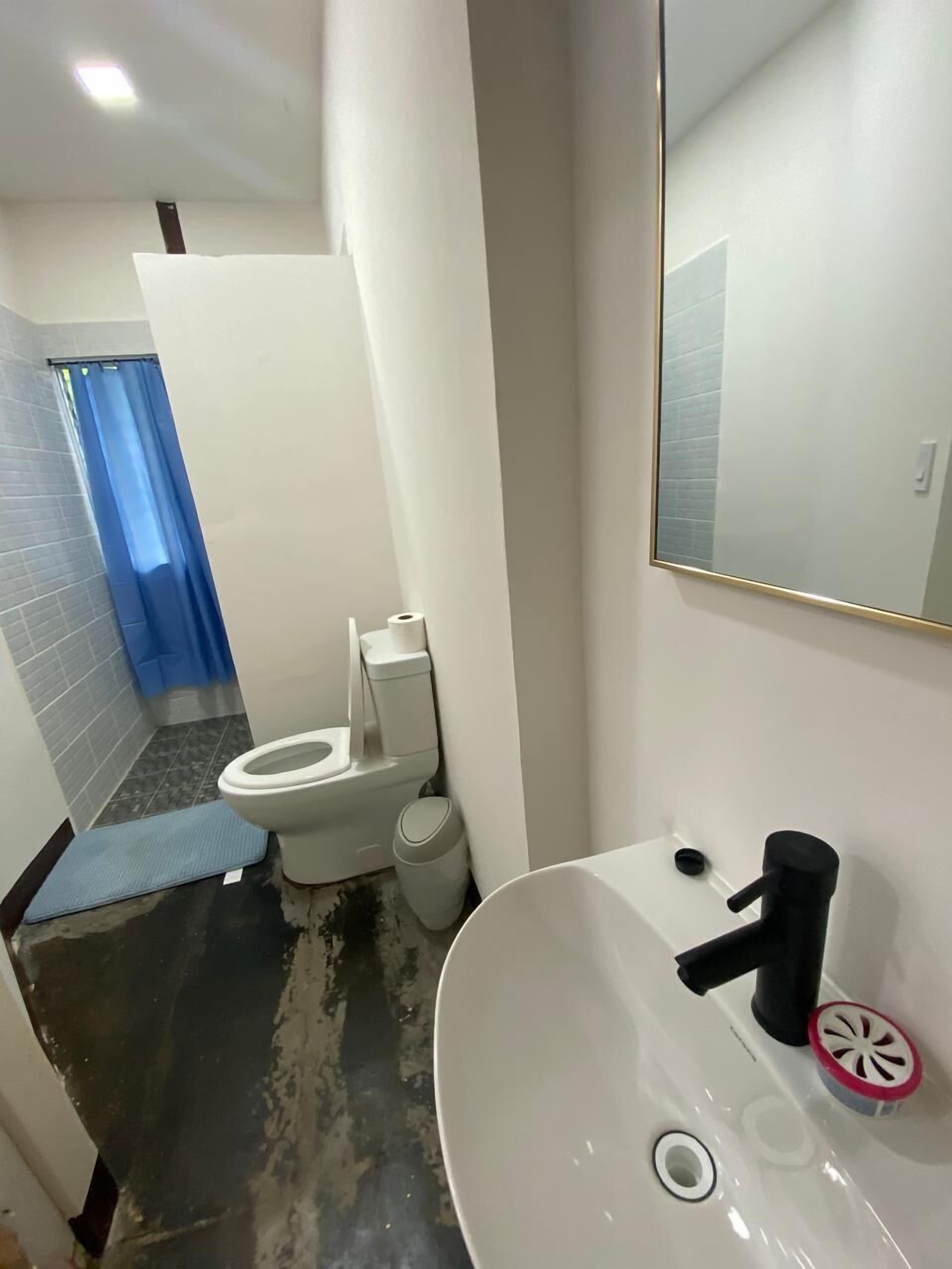 A bathroom with a white sink, a mirror, and a toilet.