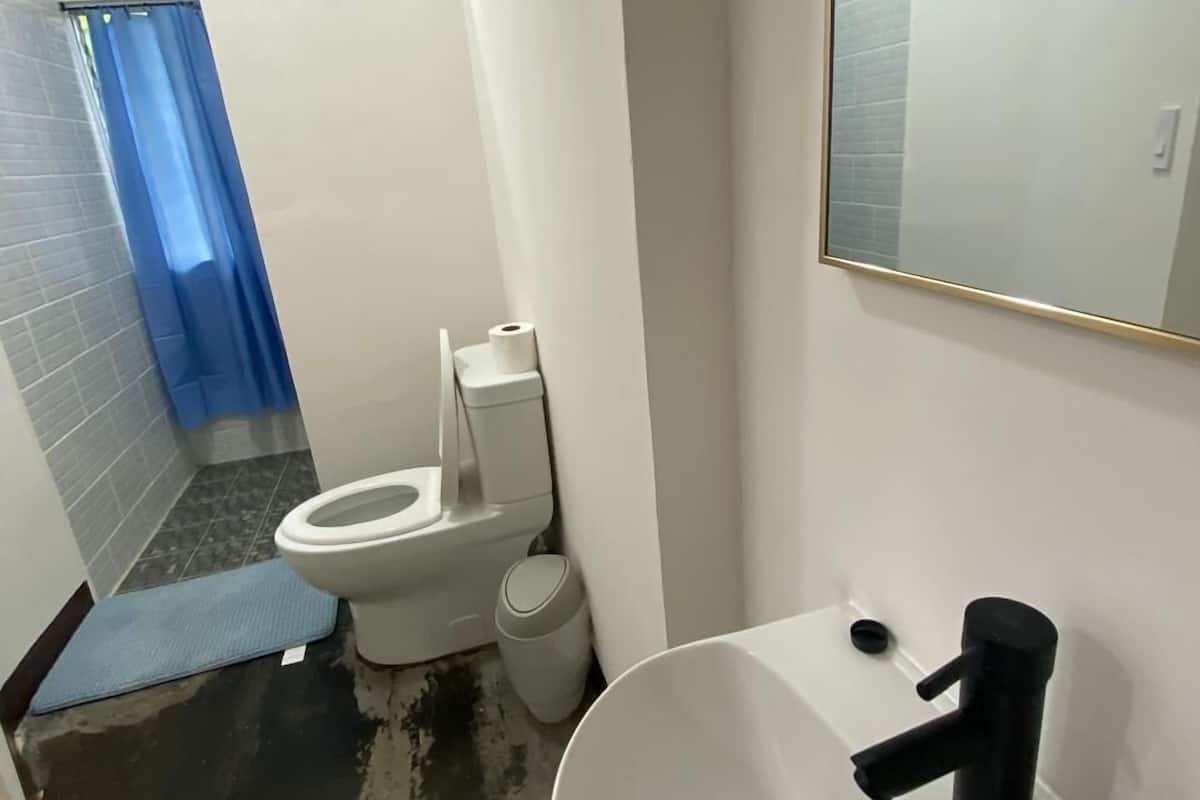 A bathroom with a white sink, a mirror, and a toilet.