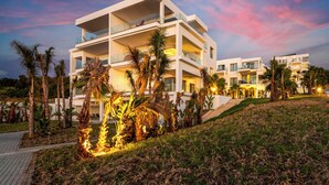 A multi-story modern building with balconies, surrounded by palm trees and a landscaped area. - Le tanger (Al Bahraoyine)