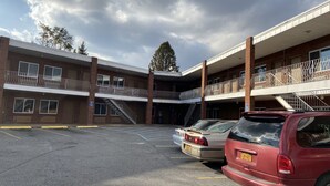 A multi-story parking garage with a brick facade, multiple levels, and a central staircase. - Deer Park Motor Inn (Deer Park)