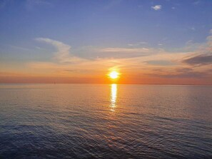 Auringonlasku tyynen meren yllä, horisontti on selkeä.