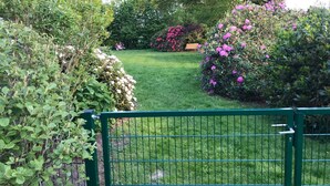 Un jardin bien entretenu, agrémenté de diverses plantes à fleurs et d’une pelouse verdoyante.