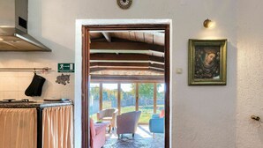A kitchen with a stove, oven, and a sign indicating the direction to the bathroom. - Wonderful private villa for 8 guests with A/C, private pool, WIFI, TV, patio and pets allowed (Muntic)