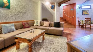 A cozy living room with a wooden sofa, a glass-top coffee table, and a staircase leading to another level. - Wonderful private villa for 8 guests with A/C, private pool, WIFI, TV, patio and pets allowed (Muntic)