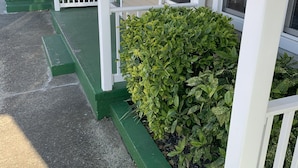 A building with a porch, a sign reading "WILMINGTON TERRACE," and a green hedge. - Wilmington Terrace (Ocean City)