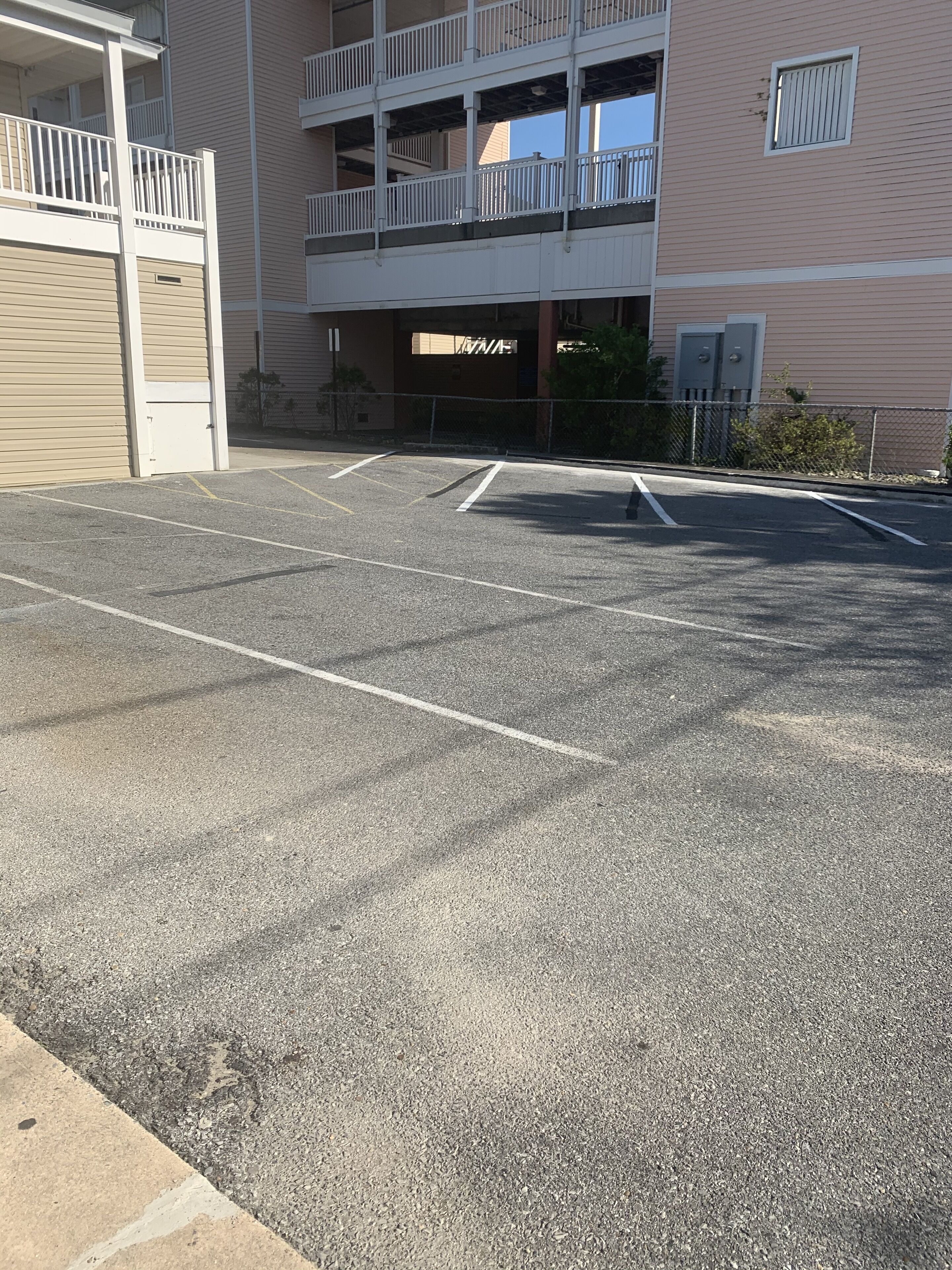 A multi-story building with a parking area in front.