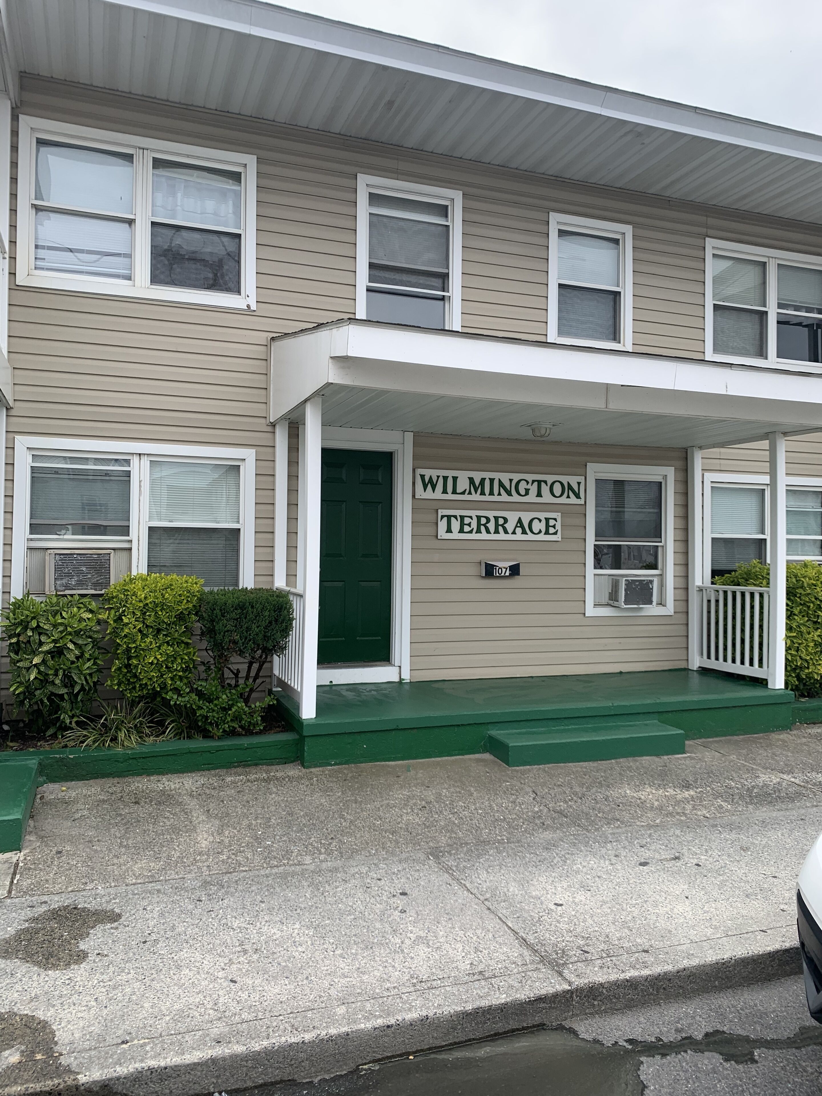 En toetages bygning med et skilt der viser ”WILMINGTON TERRACE” og husnummer ”107”.
