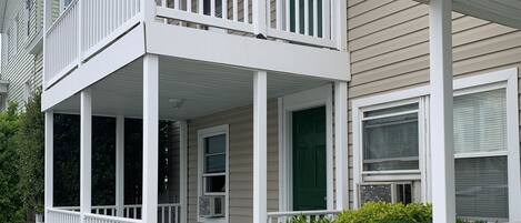 A two-story house with a covered porch and a green front step.
