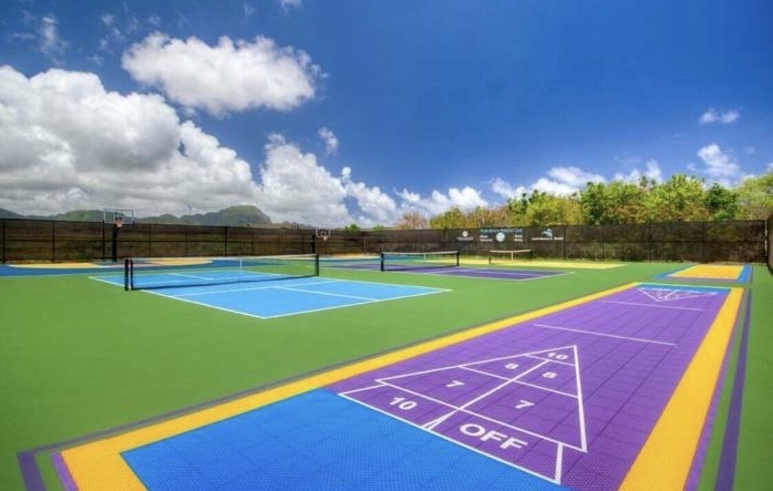 Ein Sportplatz mit mehreren Tennisplätzen und einer Shuffleboard-Bahn.