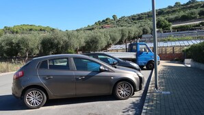 A parking area with a car and a blue truck. - Lovely apartment for 4 people with WIFI, A/C, TV, patio and pets allowed (San Bartolomeo Al Mare)