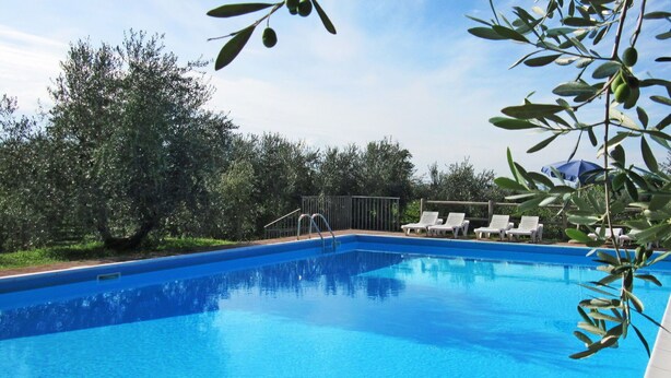 A clear blue swimming pool with a metal ladder, surrounded by white lounge chairs and a metal fence. - Lovely apartment in villa for 4 guests with A/C, WIFI, pool, TV and panoramic view (Bardolino)