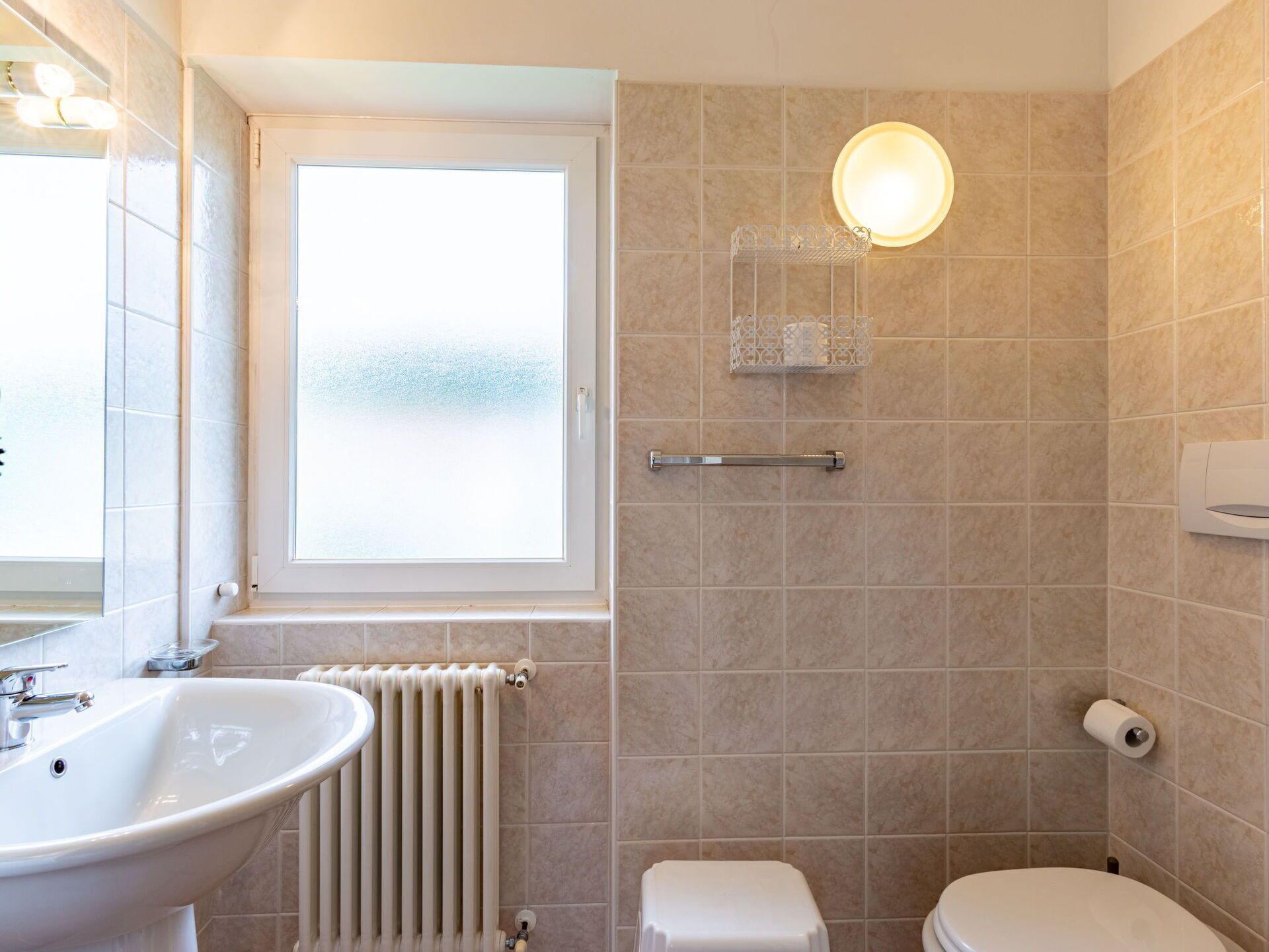 A bathroom with a sink, toilet, and shower.