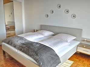 A modern bedroom with a bed, bedside tables, and a mirror. - Belvedere by Interhome (Manderscheid)