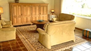 A living room with a sofa, a small round table, a cabinet, and a patterned rug. - Belvedere by Interhome (Manderscheid)