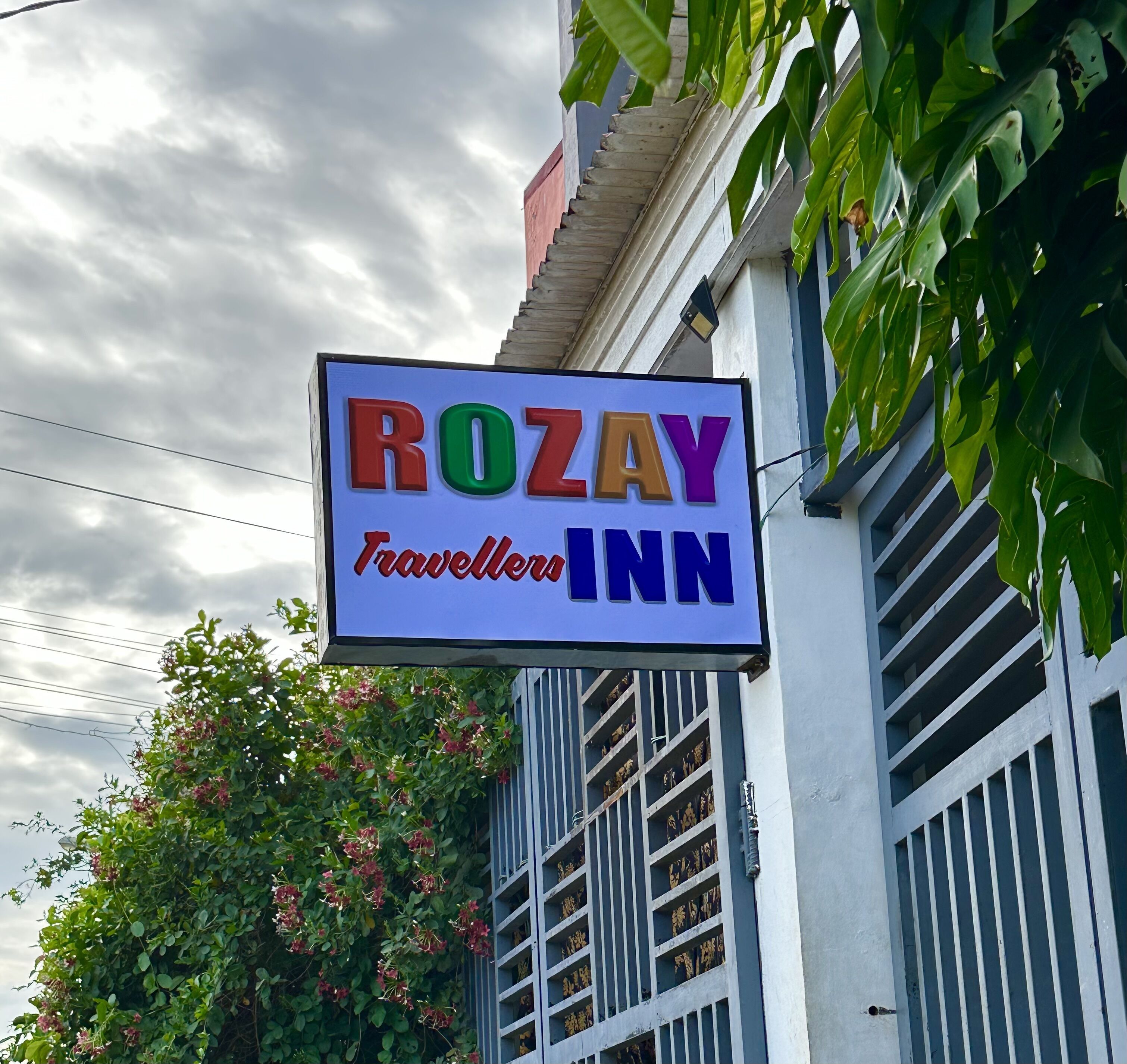 A sign for Rozay Travellers Inn with a clear view of the building's exterior.