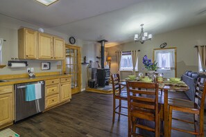 A spacious kitchen with wooden cabinets, a built-in stove, and a dining area with wooden chairs and a table.