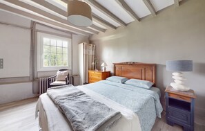 A bedroom with a bed, a chair, a dresser, a lamp, and a window. - Homerez - House in Vittefleur, garden. (Vittefleur)