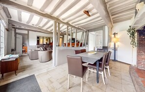 A spacious living area with a dining table, chairs, and a sofa. - Homerez - House in Vittefleur, garden. (Vittefleur)
