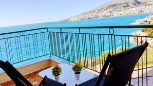 A balcony with a view of the sea and a cityscape.